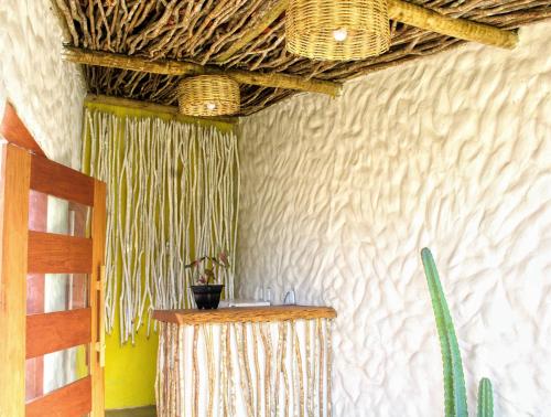 a room with a table and wicker baskets on the wall at Pousada Sal e Sol in São Miguel do Gostoso