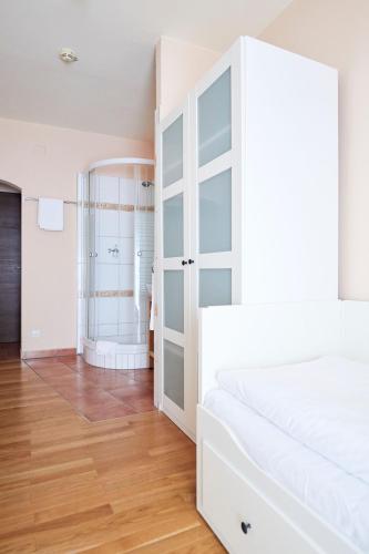 a bedroom with a white bed and a closet at Hotel San Marco in Lannach