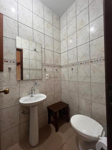 un baño con lavabo e inodoro en Itamambuca Suites, en Ubatuba