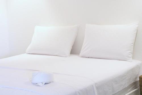 a white bed with white sheets and pillows at Pousada Sal e Sol in São Miguel do Gostoso