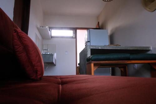 a room with a couch and a table and a refrigerator at Pousada Sal e Sol in São Miguel do Gostoso