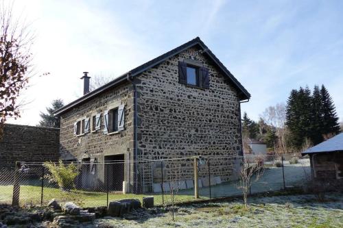 an old brick building with two windows on it at La Pierre des Volcans Chaleureux Calme Champêtre in Aydat