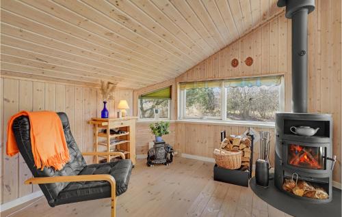 a living room with a wood stove in a cabin at Lovely Home In Faxe Ladeplads With Wifi in Fakse Ladeplads