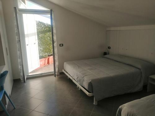 1 dormitorio con 1 cama y puerta corredera de cristal en SOLELUNA, en Albenga