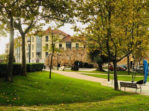 a park with a bench in front of a building at Apartamento La Bien Cercada in Zamora