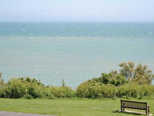 a bench sitting in the grass looking at the ocean at Apartment 9 - Uk42740 in Whitstable