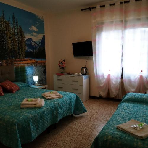 a hotel room with two beds and a television at Miralago View in Revine Lago