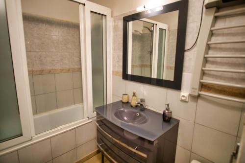 une salle de bain avec un lavabo et un miroir dans l'établissement Ref JOFFRE - Palmes d'Or Properties, à Cannes