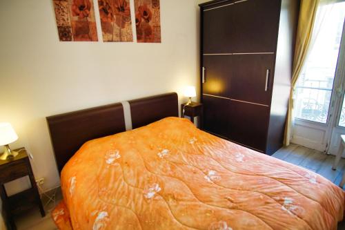 une chambre avec un lit avec une couverture orange dans l'établissement Ref JOFFRE - Palmes d'Or Properties, à Cannes
