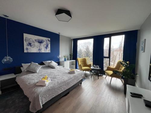 um quarto com uma cama grande com paredes e cadeiras azuis em SAS & SPA Apartament em Lublin