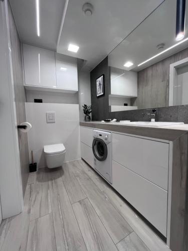uma cozinha com máquina de lavar e secar roupa na casa de banho em SAS & SPA Apartament em Lublin