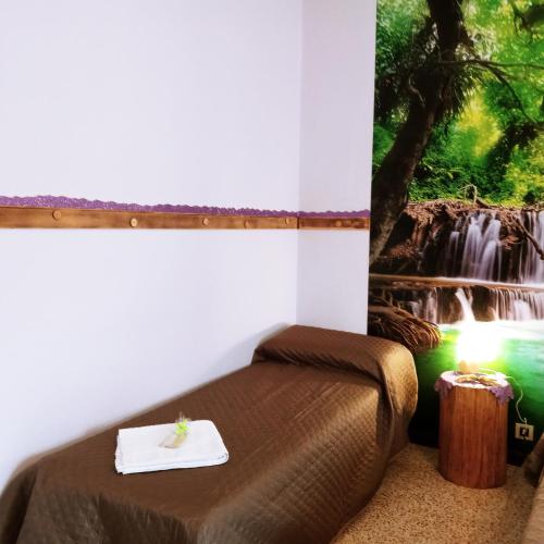 a bed in a room with a waterfall painting on the wall at Miralago View in Revine Lago