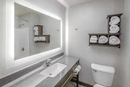 Baño blanco con lavabo y espejo en My Place Hotel-Boise-Nampa, ID-Idaho Center, en Nampa