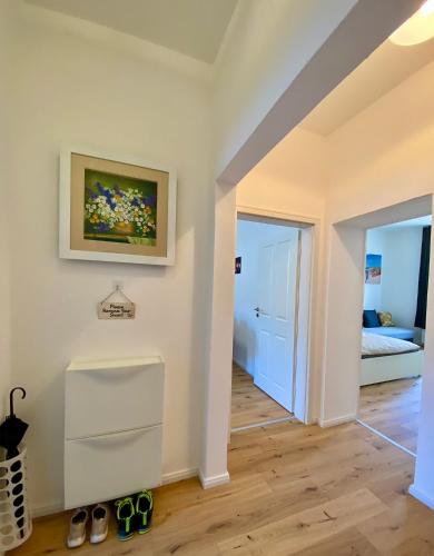 a room with a hallway with a bed and a painting on the wall at PnT home-stilvolles Apartment in Koblenz