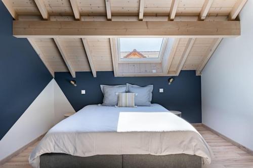 een slaapkamer met een groot bed en een raam bij Les Balcons de la Charve - Gîte 4 étoiles in Jongieux