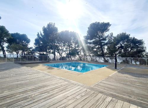 - une piscine sur une terrasse en bois bien exposée dans l'établissement SUPERBE APPARTEMENT VUE MER - PLAGE, PISCINE et TENNIS PRIVE, à Bandol