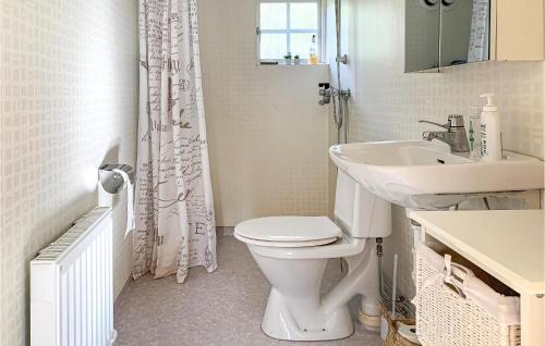 Baño blanco con aseo y lavamanos en 2 Bedroom Awesome Home In Vstervik en Västervik