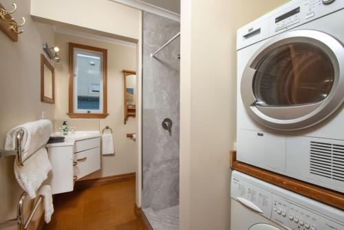 a bathroom with a washer and dryer and a sink at City Apartment South Street in Nelson