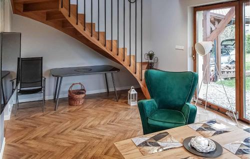 a living room with a table and a green chair at Amazing Home In Radziechowy With Kitchen in Radziechowy