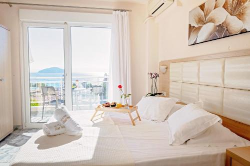 Vournelis Beach Hotel and Spa في إيراكليتسا: غرفة نوم بسرير كبير مع نافذة كبيرة
