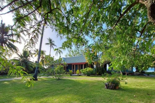 a house with a green yard with palm trees at Turia's Beach Villa in Moorea