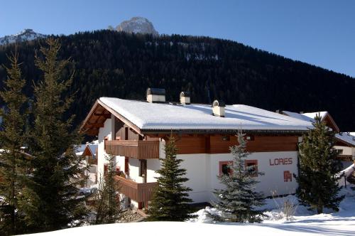a house with snow on the roof of it at Apartments Lores in Selva di Val Gardena