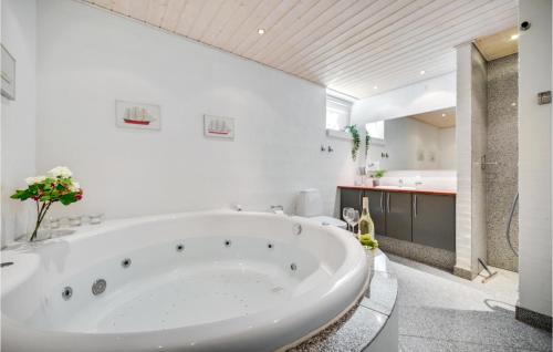 エーベルトフトにあるStunning Home In Ebeltoft With 4 Bedrooms, Sauna And Wifiの白い大きなバスルーム(大型バスタブ付)