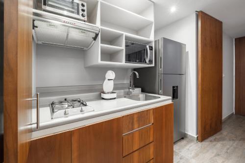 a kitchen with a sink and a refrigerator at Urban Getaway, Trendy Polanco, Home Office in Mexico City
