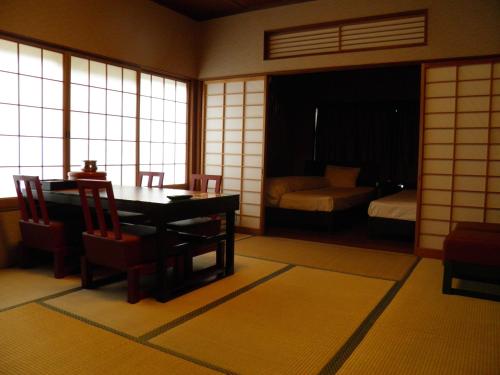 a room with a table and chairs and a bedroom at Wakanoyu in Chikuma