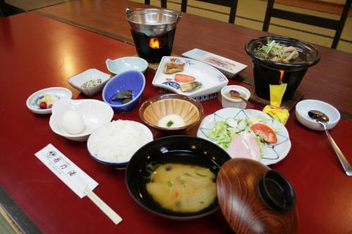 a table with a bowl of soup and bowls of food at Wakanoyu in Chikuma