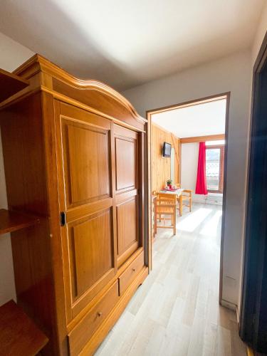 a large wooden cabinet in a room with a table at Atmosphere Hotel in Les Deux Alpes