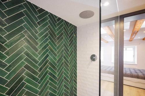 a bathroom with a green and white patterned wall at stadtmauer apartments - Neue helle Studio Wohnung direkt an der historischen Stadtmauer in Nördlingen