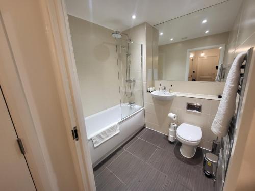 a bathroom with a toilet and a shower and a sink at Garland Apartment, Greenhithe 3 in Dartford