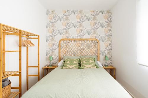 ein Schlafzimmer mit einem Bett mit zwei grünen Kissen in der Unterkunft COZY & MODERN APARTMENT in Málaga