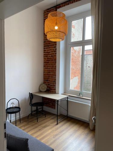 a room with a desk and a brick wall at Urokliwy loft w NCŁ kamienica Vabank 34 in Łódź