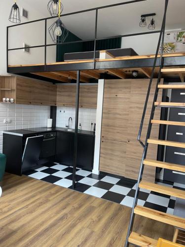 a loft kitchen with a bunk bed and a checkered floor at Urokliwy loft w NCŁ kamienica Vabank 34 in Łódź