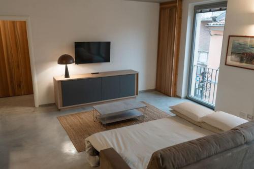 a living room with a couch and a flat screen tv at Recinto Nobili 1-private parking su richiesta in Asti