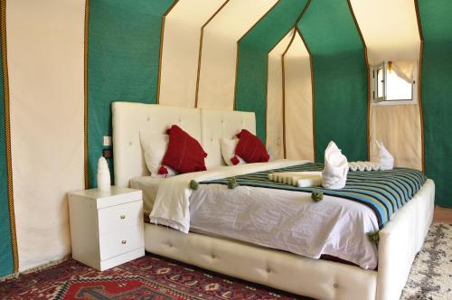 1 dormitorio con 1 cama con espejo grande en merzouga fatima Appart hotel &Camp, en Merzouga