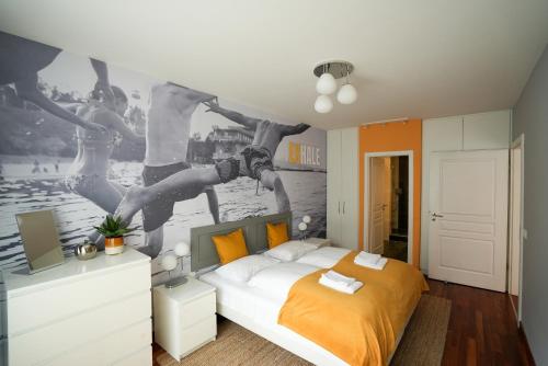 ブダペストにあるHolló 12 Apartmentのベッドルーム1室(ベッド1台付)が備わります。壁には人々の絵画が飾られています。