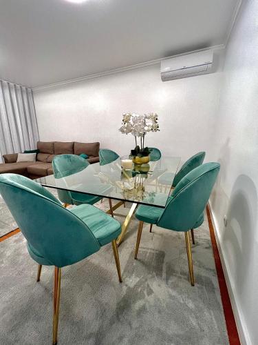 a dining room with a glass table and green chairs at Funchal Lido View 1 in Funchal