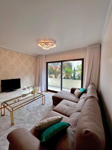 a living room with a large couch and a tv at Funchal Lido View 1 in Funchal