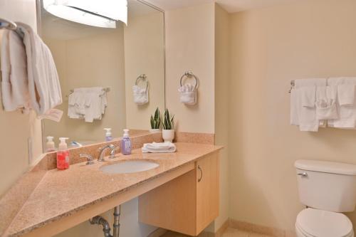 a bathroom with a sink and a toilet and a mirror at Gorgeous Condo 3 Br 3 Balconies SB 11th Floor in Myrtle Beach
