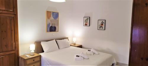 a bedroom with a white bed with two shoes on it at Canevaro Twins (South) in Chania