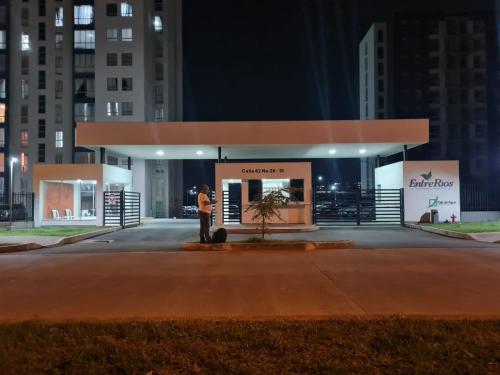 APARTAMENTO SECTOR CONDINA cerca estadio-ukumari-consota-expofuturo في بيريرا: امرأة تقف أمام مبنى في الليل
