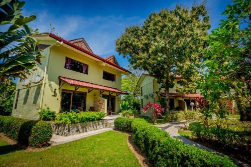 a yellow house with a garden and a tree at Beringgis Beach Resort & Spa in Papar