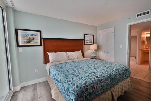 a bedroom with a large bed with a blue blanket at Gorgeous Condo 3 Br 3 Balconies SB 11th Floor in Myrtle Beach