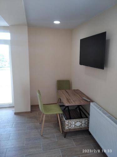 a room with a table and a television on a wall at Komfortni apartament riadom s metro in Tbilisi City