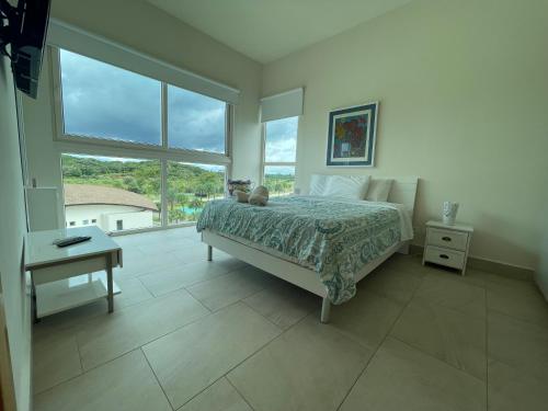 a bedroom with a bed and a large window at Apartamento en el mar Caribe, Playa Escondida Resort & Marina in María Chiquita