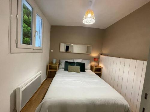 une chambre avec un grand lit blanc avec une fenêtre dans l'établissement *NEW* MAISONNETTE*Bail Mobilité*CHIC*NANTES, à Nantes
