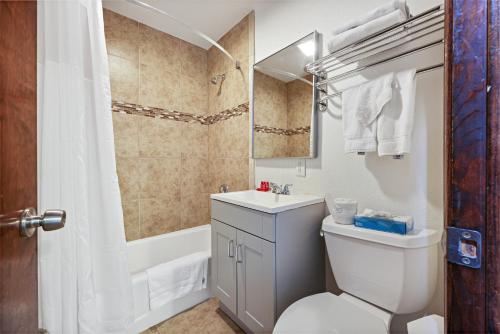Un baño con inodoro, lavabo y bañera. en Hotel Point Loma, en San Diego